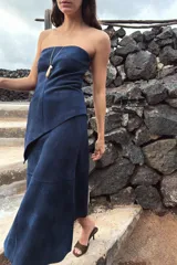 Top strapless de tejido con efecto ante en color azul marino, con diseño de escote recto y bajo asimétrico con terminación en punta. Cuenta con cierre lateral oculto.