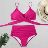 Conjunto de bikini negro de tiro alto, compuesto por un corpiño triangular con diseño cruzado en el frente y tirantes finos regulables, y una bombacha de corte clásico y talle alto.