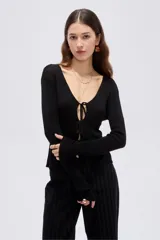 Top de manga larga en tejido de punto con lurex, color negro, de corte ajustado al cuerpo, con escote en V pronunciado y cierre delantero mediante finos lazos para anudar.
