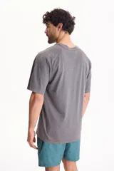 Remera oversize de manga corta raglán, color negro con efecto lavado acid wash, corte semi boxy y detalle de etiqueta lateral en el ruedo.