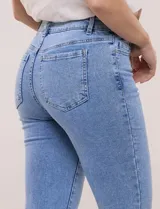 Jean skinny de tiro medio con calce ajustado, cintura con presillas y acceso frontal con cierre y botón metálico. Presenta diseño clásico de cinco bolsillos y pierna entallada de largo al tobillo.