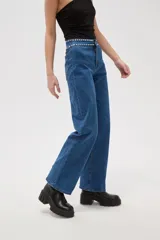 Pantalon de jean negro de corte recto y tiro alto, con detalle de tachas metálicas en la cintura.