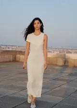 Vestido largo de tejido de punto en canalé color blanco, de corte entallado, con cuello redondo y diseño de mangas asimétricas.