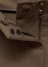 Pantalon de vestir de tiro medio con corte flare y diseño largo. Cuenta con dos bolsillos laterales y cierre frontal con cremallera, botón y ganchos ocultos bajo tapeta.