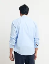Camisa de cuello mao y manga larga, confeccionada en una mezcla de lino y algodón. Presenta un diseño de corte recto con botones en tono natural y un bolsillo pequeño en el pecho.
