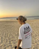 Remera blanca de manga corta, corte regular y cuello redondo, con gran estampado en la espalda de temática "Worldwide Tour" con una calavera y texto en rojo, azul y blanco.