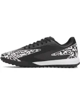 Championes de fútbol Under Armour Shadow Turf 3, diseñados para césped artificial. Presentan un diseño en color negro con detalles estampados en blanco y negro tipo pixelado. Cuentan con entresuela Charged Cushioning para absorción de impactos y suela de goma con tacos estratégicos para máximo agarre.