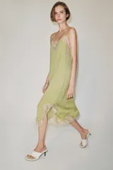 Vestido midi confeccionado en hilatura de viscosa, de color verde con detalles de encaje a contraste en el escote y el bajo. Cuenta con escote recto y tirantes finos ajustables.