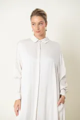 Vestido camisero largo color marfil, de satén de seda, con cuello camisero, mangas largas y bolsillos laterales.