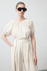 Pantalón baggy negro de silueta relajada con volumen amplio y caída fluida. Presenta detalles de ajuste con hebillas metálicas en el bajo y un cinturón de tela con hebilla metálica en la cintura.