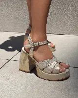 Sandalias de fiesta doradas con plataforma y taco cuadrado. Tiras cruzadas en el empeine y pulsera con hebilla al tobillo.
