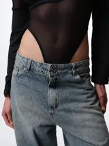 Body negro de cuello alto y manga larga, confeccionado con paneles de tela translúcida y un bandeau opaco en el busto.