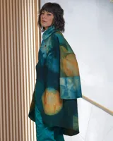 Tapado de lana merino afieltrada con teñido artesanal tie dye en tonos verdes y ocres. Tiene cuello alto, cierre cruzado asimétrico con broches, bolsillos laterales y corte holgado.