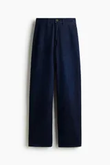 Jean de denim de algodón rígido color azul oscuro, con tiro alto y pierna ancha recta. Cuenta con cierre y botón frontal, bolsillos clásicos y diseño de corte holgado.