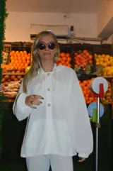 Canguro blanco de tejido waffle con capucha, cierre parcial con botones de madera y bolsillo tipo canguro.