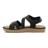 Sandalias de mujer color negro, con tiras cruzadas en el empeine, ajuste elástico en el tobillo y suela plana marrón claro.
