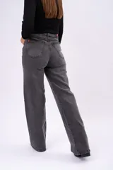 Pantalón de jean corte wide leg en color negro gastado, con tiro alto y estructura rígida.