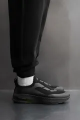 Zapatilla deportiva negra sin cordones para uso diario y carreras ligeras. Parte superior de tejido de punto transpirable, puntera y talón recubiertos de material Shield Protect Max, tirador trasero, plantilla OrthoLite® extraíble, entresuela con tecnología Spume Foam V3 y suela de goma. Zara Athleticz.