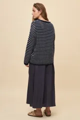 Sweater de tejido amplio en color azul marino con diseño de rayas horizontales y detalles calados. Cuenta con cuello redondo, mangas largas con hombros caídos y terminaciones acanaladas.