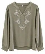 Blusa verde seco con cuello en V, manga larga abullonada con puños y detalles bordados en blanco en el pecho. Presenta encaje en las costuras de los hombros.