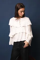 Blusa de lino color blanco, con silueta oversize, cuello bote y volados en el frente.