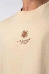 Remera de corte oversize color verde oliva, confeccionada en algodón premium. Presenta un diseño minimalista con un pequeño estampado frontal de un sol y el texto VCP Concept Studio, y una gráfica protagonista en la espalda.