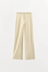 Pantalón negro de tejido de punto, tiro alto, con cintura elástica y detalle de tres botones frontales. Corte de pierna recta y ancho.