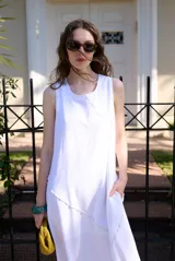 Vestido midi blanco sin mangas, de corte recto y holgado, con detalle de costura diagonal en relieve.