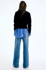 Jean wide leg de tiro alto en denim rígido de lavado claro, con diseño de cinco bolsillos y perneras amplias y holgadas.