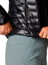 Campera puffer negra ultraligera para mujer, con capucha y cierre frontal. Confeccionada con tejido exterior reciclado y aislamiento de plumón de origen responsable con certificación RDS.