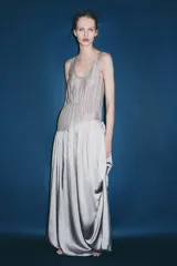 Vestido largo de tirantes con escote redondo, confeccionado en mezcla de viscosa. Presenta un diseño combinado con la parte superior en tejido ligero semitransparente y la parte inferior con volumen y drapeado asimétrico.