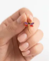 Aros pequeños de acero en forma de libélula con detalles esmaltados en colores violeta y rojo.