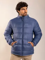 Campera puffer azul con cuello alto y cierre frontal. Interior forrado en sherpa color crema.