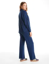 Cardigan abierto de denim, de corte holgado y recto, con solapas amplias, bolsillos frontales funcionales y hombros caídos.