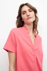 Blusa fucsia de lino con cuello mao y volados, corte recto y mangas cortas.