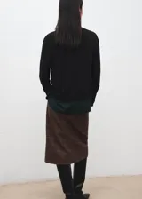Cardigan de punto fino color negro, de corte recto, con escote en V, mangas largas y cierre frontal de botones.