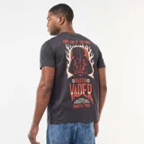 Remera de algodón color negro, de corte clásico y cuello redondo, con estampa frontal pequeña en el pecho con el logo de Star Wars en tonos rojos y el emblema del Imperio Galáctico.
