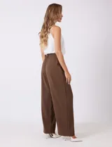 Pantalón palazzo de tiro alto en color verde militar, con diseño de doble abotonadura frontal, pinzas en la cintura y pierna ancha. Cuenta con cintura elástica en la parte posterior para mayor ajuste y bolsillos laterales funcionales.