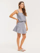 Musculosa de lino a rayas verticales azules y blancas, con breteles anchos y ruedo con flecos.