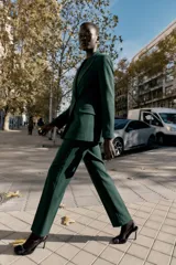 Pantalón de tiro alto color negro, de corte recto, con bolsillos delanteros y cierre frontal con cremallera y ganchos metálicos.