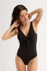 Malla entera negra con escote en V y detalle de nudo en el centro del busto.