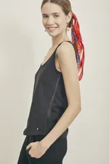 Musculosa negra de algodón peinado, con escote redondo y corte al cuerpo. Presenta un detalle de tejido calado en el lateral.