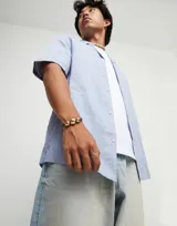 Pulsera de cuero negro con tres cuentas esféricas grandes de aleación de metales bañadas en oro de 18k.