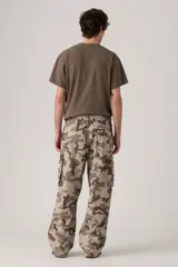 Pantalón cargo de corte amplio con estampado de camuflaje en tonos beige, marrón y verde. Cuenta con cintura elástica ajustable con cordón, bolsillos laterales con solapa y bolsillos traseros.