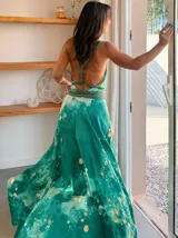 Vestido largo verde con diseño estampado tipo tie-dye y detalles dorados, de corte fluido, un solo hombro y diseño amplio.