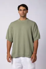 Remera de tejido de punto liviano en color verde oliva, con corte oversize, cuello redondo acanalado y mangas cortas con terminación en rib.