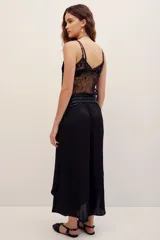 Falda midi color negro, de corte fluido, con detalles de costuras y diseño asimétrico.