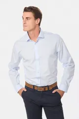 Camisa celeste de vestir, entallada, de manga larga, con cuello clásico y sin bolsillo.
