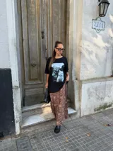 Conjunto compuesto por un remerón negro de algodón con estampa fotográfica frontal y una pollera midi de satén con estampado animal print de leopardo.