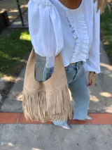 Cartera tipo hobo de cuero color beige con flecos en dos niveles.